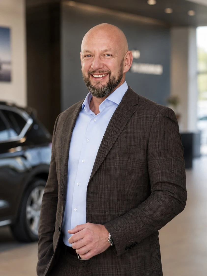 Porträt von Arkadius Biernat, Gründer von DealerMate, in einem Autohaus-Showroom